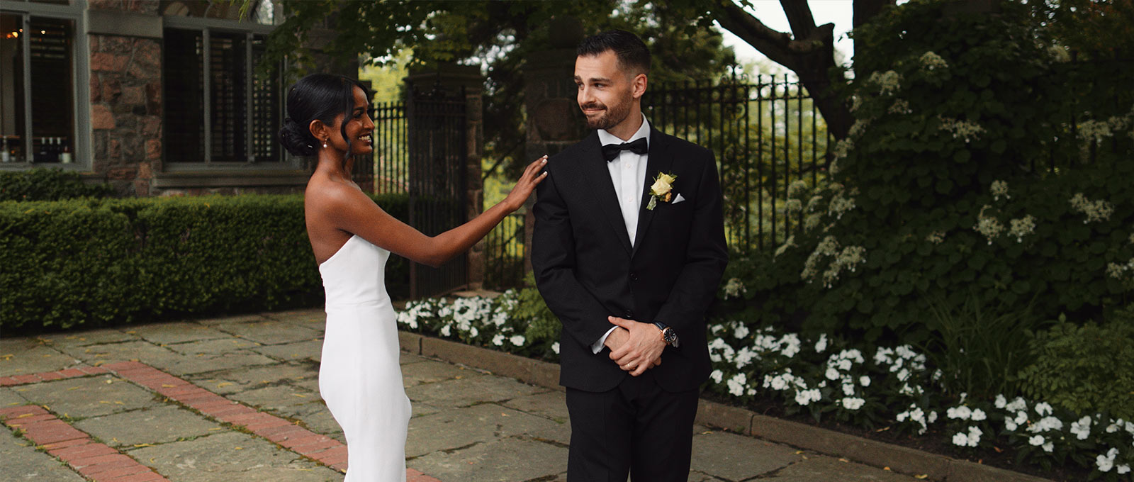 Bride and groom share a first look in Graydon Hall's front courtyard at dusk.