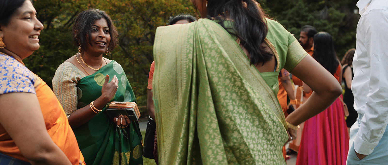 Woman in saree smiles during outdoor cocktail hour at Graydon Hall Manor.